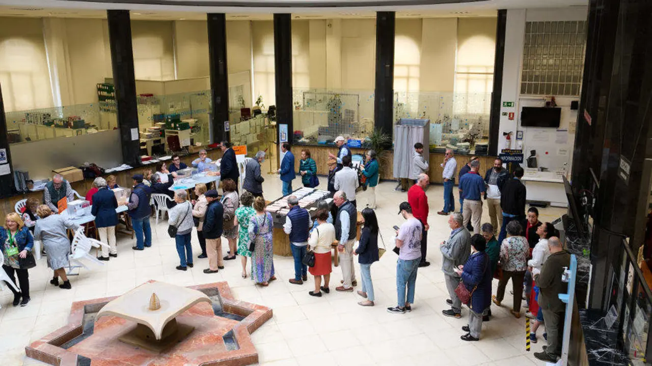 Varias peronas ejercen su derecho al voto en el Ayuntamiento de Santander