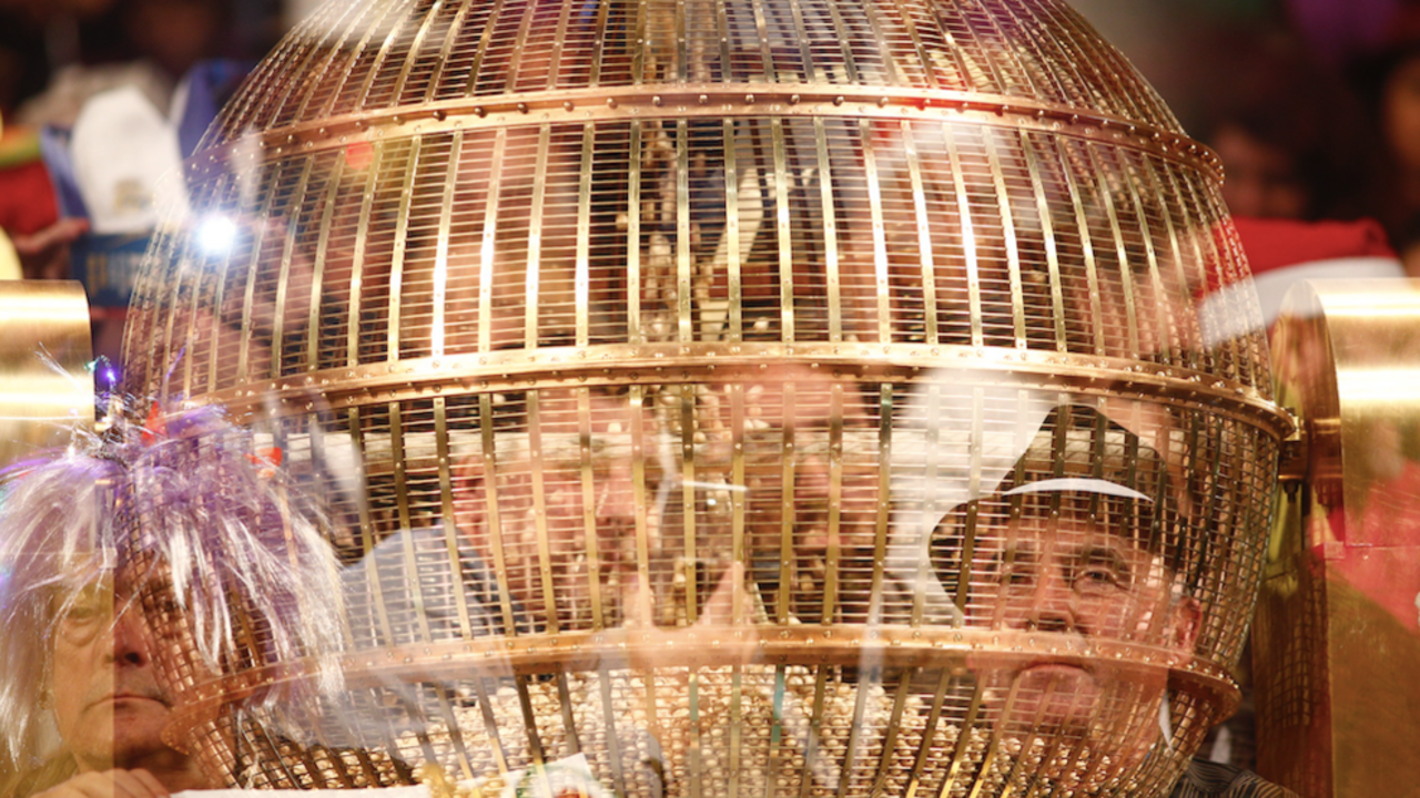 Personas disfrazadas detr&aacute;s de un bombo esperan en el Teatro Real de Madrid para disfrutar del Sorteo Extraordinario de la Loter&iacute;a de Navidad