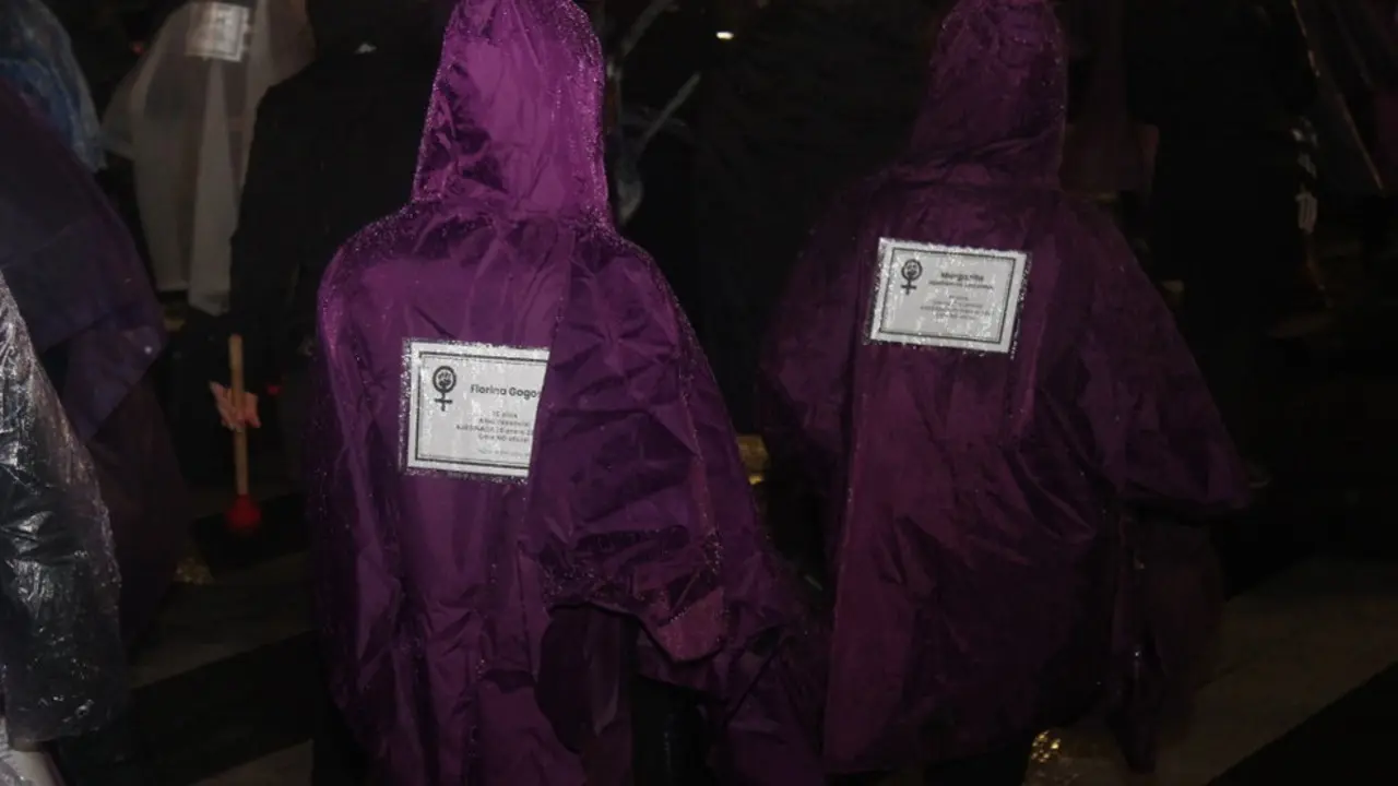 Esquelas de las mujeres asesinadas por violencia de g&eacute;nero en las espaldas de algunas manifestantes en el 25N
