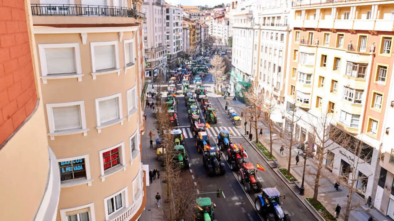 Manifestantes y tractores, con pancartas y banderas de Espa&ntilde;a, en una marcha hacia la Plaza de Correos