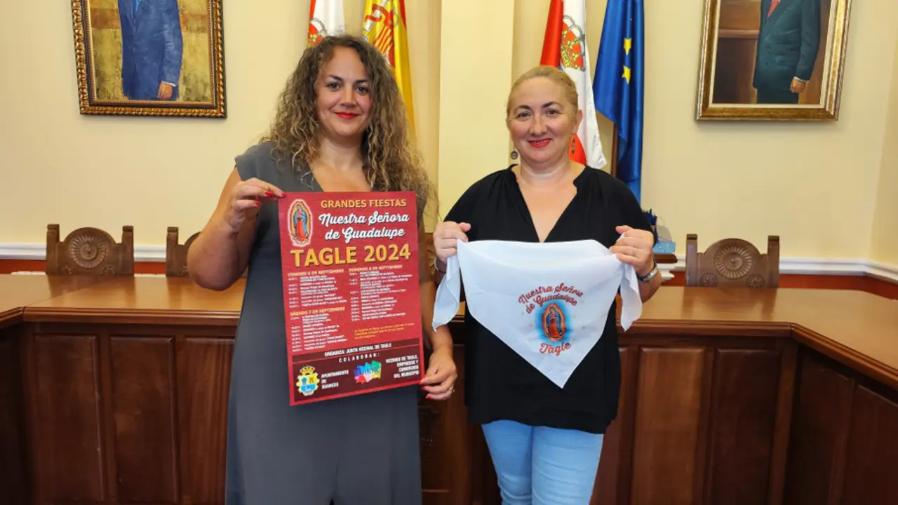 La concejala Raquel Fern&aacute;ndez y la presidenta de la Junta Vecinal, Rebeca Pern&iacute;a, con el cartel y el pa&ntilde;uelo de las fiestas de Guadalupe