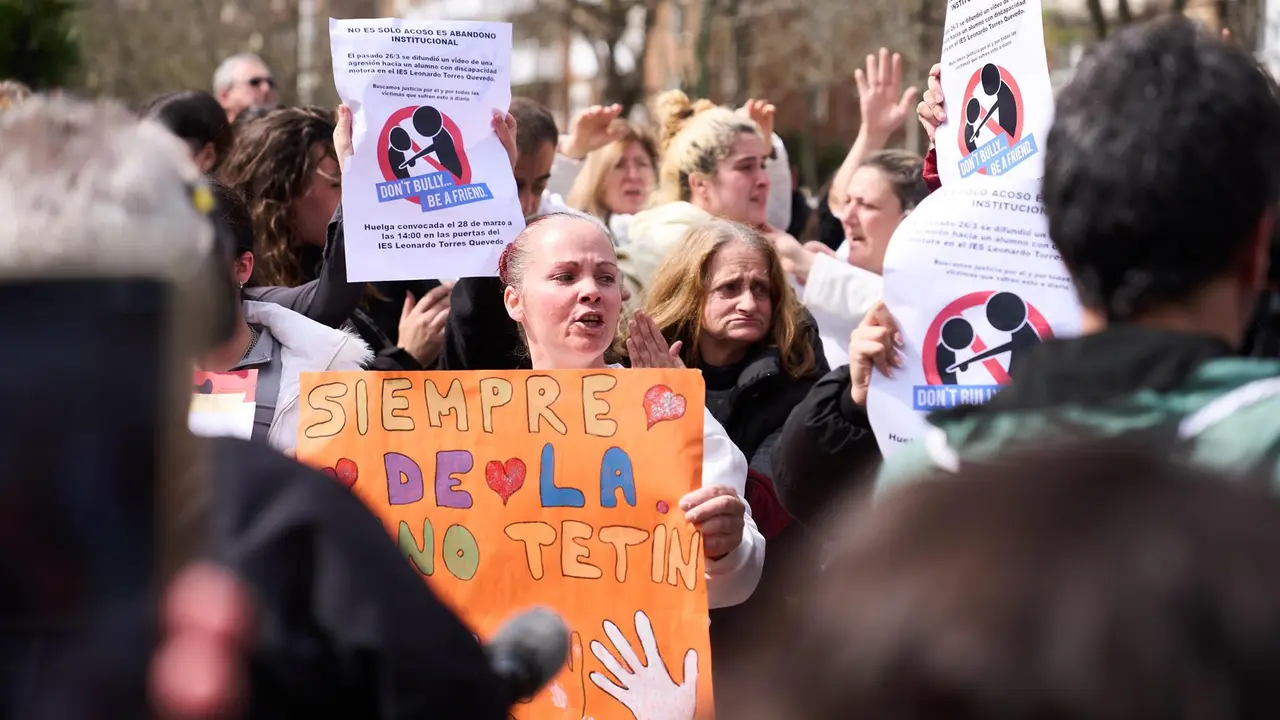 Varias personas con carteles durante una concentración de apoyo al joven agredido en el IES Torres Quevedo
