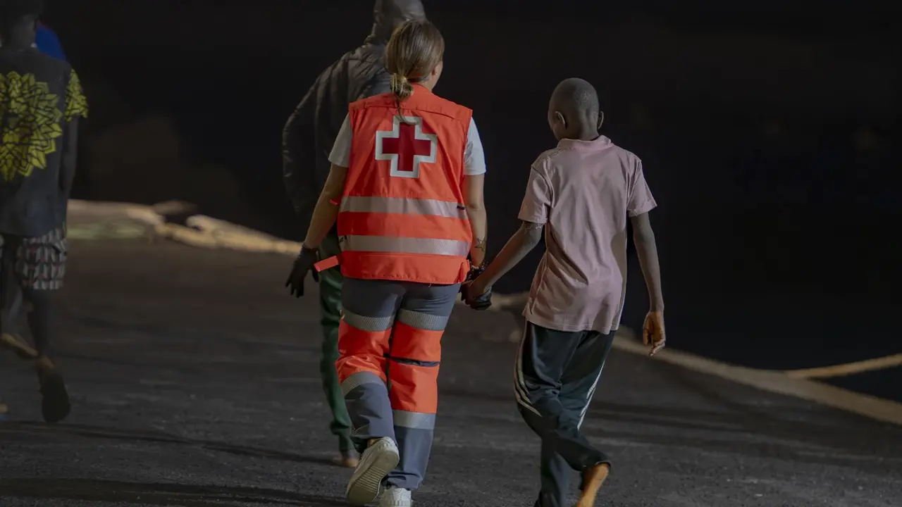 Un trabajador de la Cruz Roja atiende a un migrante