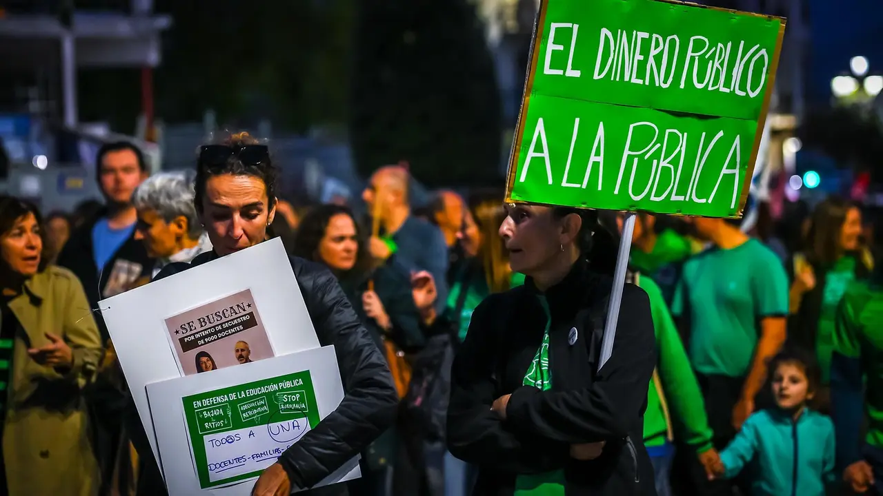 Varias personas con pancartas, durante una manifestación del profesorado cántabro por la adecuación salarial