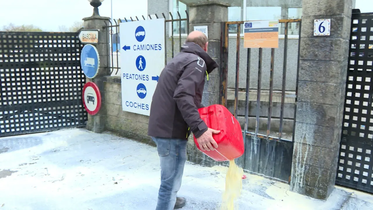 Manifestantes rocían con bidones de leche la puerta de entrada de la Fábrica Leche Celta