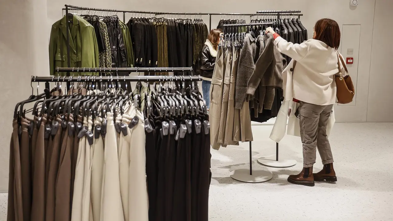 Archivo - Una mujer ve la ropa en una macrotienda de Zara.