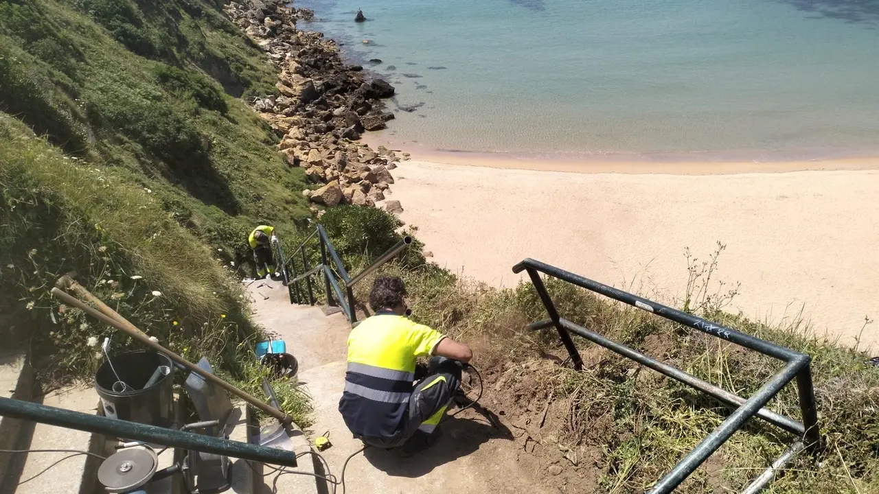 Personal de Piélagos repara la barandilla de acceso a la playa de Somocuevas tras la autorización de Costas 